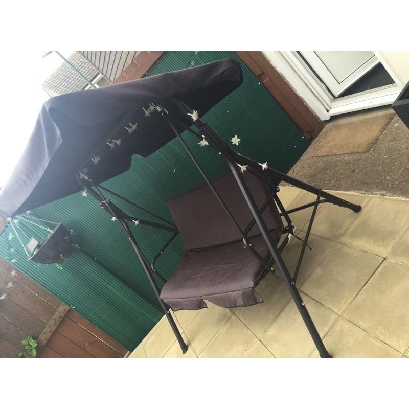 BLACK TWO SEATER HAMMOCK WITH CUSHION. ALSO SPARE BRAND NEW SEAT CUSHION AND A RAIN COVER
