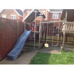 Children's climbing frame with slide and swings